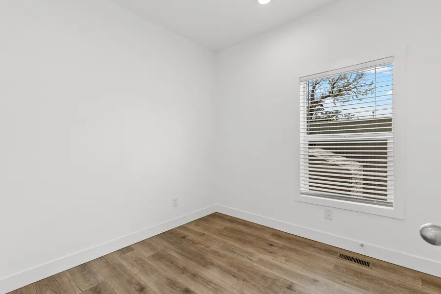 Primary bedroom with a window and vinyl plank flooring