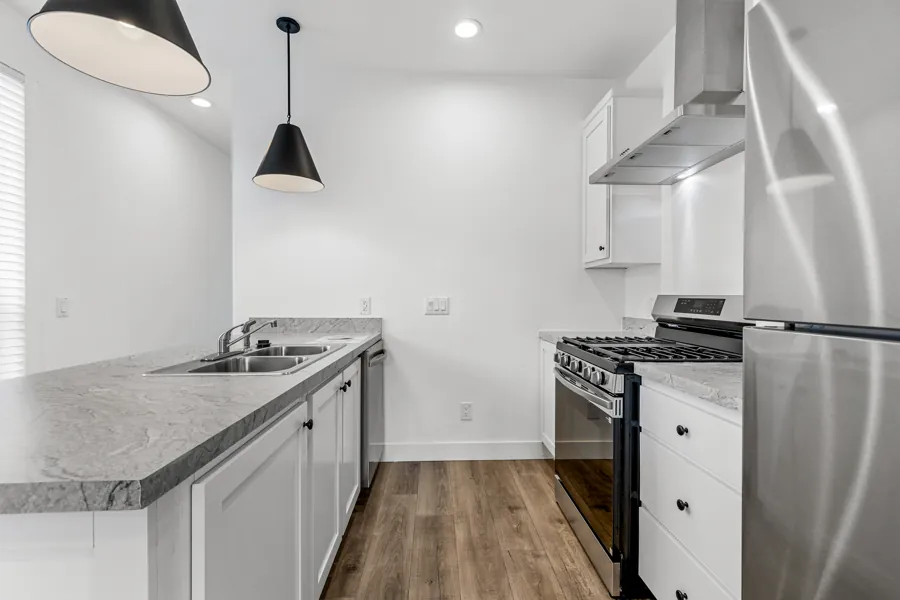 Kitchen with white shaker cabinets, stainless steel range and refrigerator